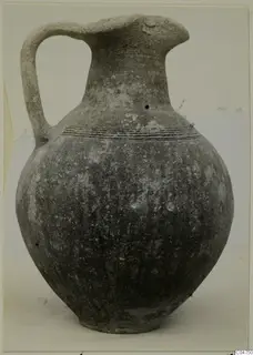 Pottery Black Slip Ware jug with a single strap handle and incised lines around the shoulder