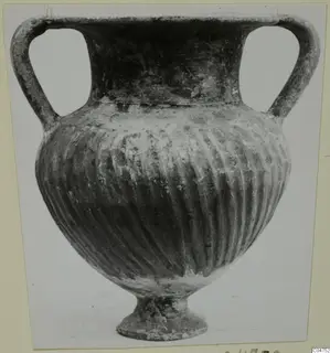 Pottery Black Slip Ware vessel with two handles, a fluted body and a low foot