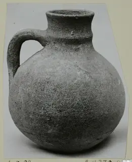 Round-bodied jug with a single loop handle and a tall flared neck, photographed on a plain background.