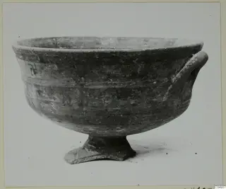 Pottery White Painted III bowl on a low pedestal foot, with one handle on the right