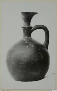 Pottery jug with a flaring neck, single loop handle and horizontal ridged bands on the body