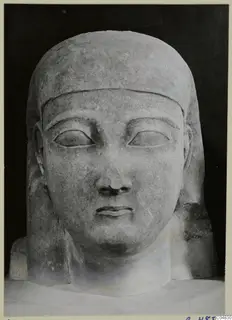 Limestone Cypro-Egyptian head and bust sculpture, facing forward against a black background