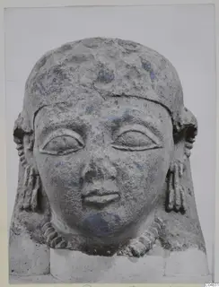 Limestone Neo-Cypriote head seen from the front, with carved eyes, nose and mouth and traces of blue paint