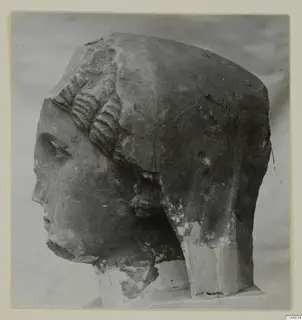 Stone statue head from Arsos, turned to the left on a plinth against a plain grey backdrop.