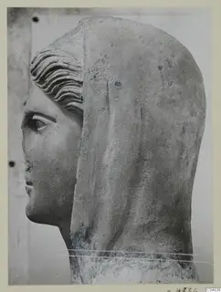 Stone statue head from Arsos, shown in profile facing left, with a veil or hood falling behind it.