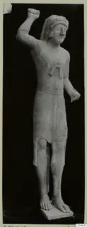 Limestone statue of a standing figure from Kition, one arm raised with a clenched fist