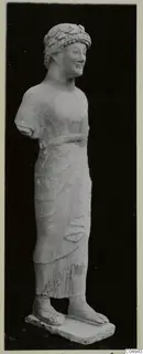 Limestone statue of a standing figure from Kition, wearing a leafy wreath and a long draped garment