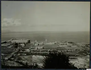 Ruins of the palace at Vouni, with low wall foundations in the foreground and the sea and distant hills beyond.