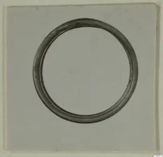 Hair-ring from Enkomi, a plain circular ring photographed on a light card.