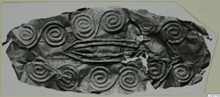 Thin metal sheet with embossed spiral pattern and three raised horizontal ridges across its centre
