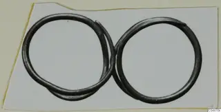 Two dark metal rings interlinked on a white card