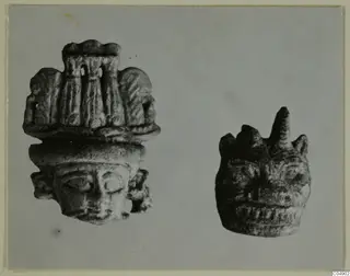 Two small head figures from Amathus, side by side on a plain grey background