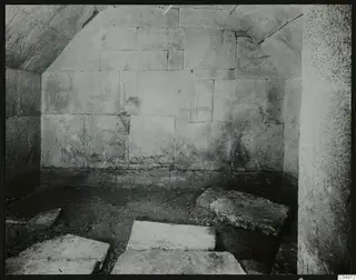 Interior of Tomb 2 at Amathus, showing large stone-block walls and a curved stone ceiling.