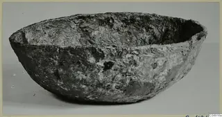 Encrusted bowl with a rounded body and flared rim, photographed on a plain background from Enkomi