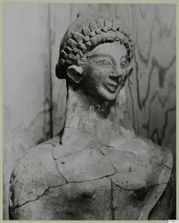 Terracotta head and upper torso of a statue, Mersinaki, with curled hair and cracks across the shoulders