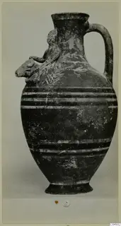 Jug from Marion with a modelled animal head on the shoulder, a strap handle and dark bands around the body