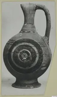 Pottery Bichrome-Red jug with a flaring neck, strap handle and concentric circles painted on its body