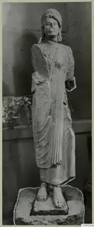 Limestone statue of a standing woman from Vouni, shown against a wooden panelled wall