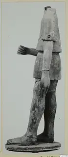 Headless terracotta statue of a standing figure on an oval base, one arm bent forward with the hand closed