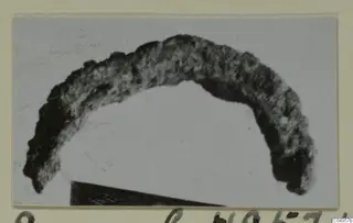 Corroded bronze personal adornment from Amathus, shaped as a curved arc