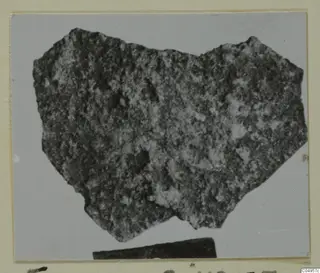 Pottery sherd from Amathus with a rough, pitted surface, photographed on a grey card mount