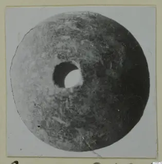 Stone disc with a central hole, from Amathus tombs 2-26, photographed on a card mount