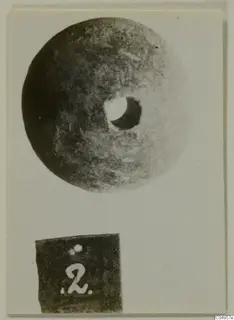 Stone disc with a central hole, photographed on a card beside a number label, from Amathus