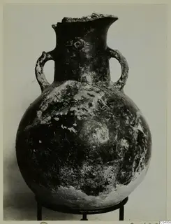 Red Polished II amphora from Lapithos, globular with two loop handles and a broken rim, shown on a stand