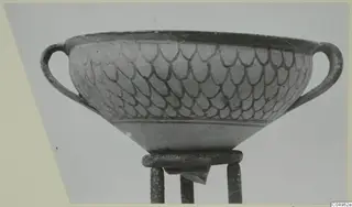 Two-handled bowl with a dark overlapping scale pattern, shown on a metal stand