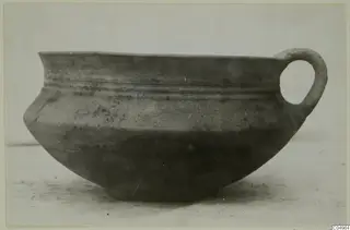 Pottery Bichrome Wheel-made bowl from Milia with a single loop handle, shown alone on a pale surface