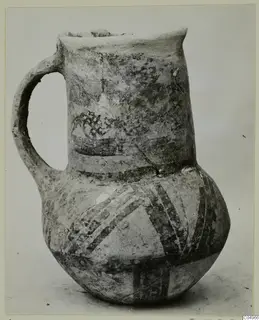 White Painted jug with a single handle and a flared neck, decorated with dark painted bands.