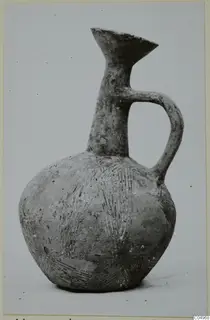 Pottery Black Slip Ware jug from Milia with a single loop handle and incised lines on its body