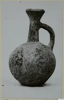 Pottery jug in Black Slip Ware with a single loop handle and banded decoration, from Milia