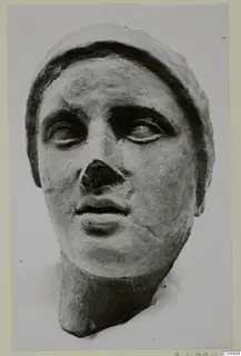 Sculpted head from Mersinaki with a broken nose and a wide band framing the head.