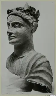 Bust of a figure wearing a leafy wreath and a draped garment, photographed in three-quarter view against a pale background
