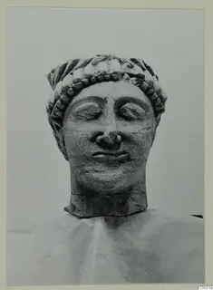 Limestone head from Mersinaki with downcast eyes and a band of curled hair across the brow