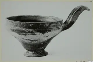 Base-Ring Ware bowl from Enkomi with a tall, curved handle rising from the rim.