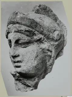 Marble head fragment of a figure, three-quarter view, broken at the neck and chin.