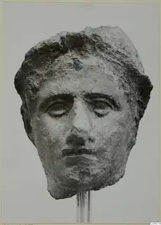 Fragment of a sculpted face, a head from Mersinaki shown on a metal rod stand