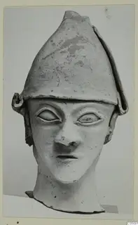 Terracotta head from Ayia Irini with a tall conical cap, large almond-shaped eyes and a long neck