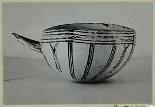 Bowl with a long projecting handle, painted with black bands, wavy lines and vertical stripes; Enkomi find photograph