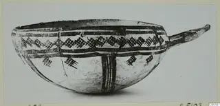 Pottery White Slip Ware bowl with a long handle, painted with dark bands and a lattice pattern