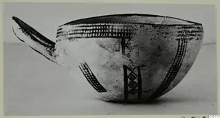 White Slip Ware bowl with a long spout, decorated with dark cross-hatched bands and vertical stripes