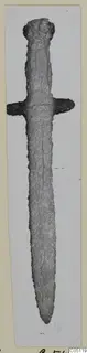 Iron dagger with a short crossguard and pointed tip, photographed upright on a pale mounted card