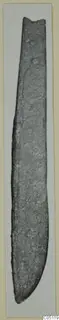 Iron knife from Idalion, a long narrow blade with a rounded point and corroded surface.