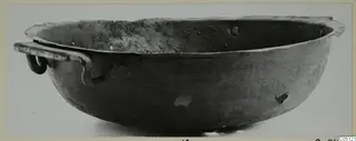 Bowl with a handle from Marion, seen from the side against a pale background.