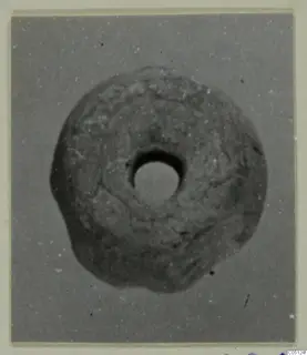 Ring-shaped object with a central hole, photographed close up, from the Kastros tombs at Lapithos