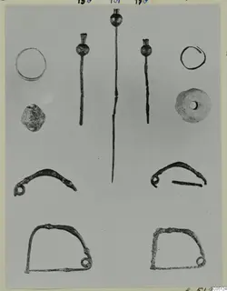 Rings, pins, pendants and a stone object from the Kastros tombs at Lapithos, laid out in rows on a grey background.