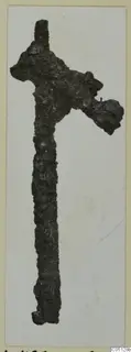 Corroded iron weapon from the Kastros tombs at Lapithos, shown upright against a pale background.