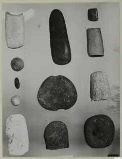 Stone objects from Petra Tou Limniti, tools and pebbles laid out in rows on a pale background